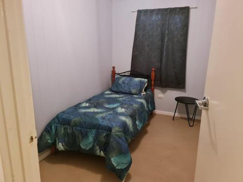 库伯佩迪City Centre Apartments的一间卧室配有一张带蓝色棉被的床和窗户。