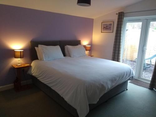 迪德科特Garden Apartment的卧室配有一张带白色床单和枕头的大床。