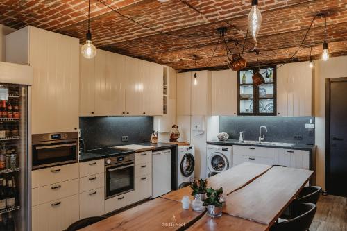 赫拉尔兹贝亨Gavershof的厨房配有白色橱柜和木桌
