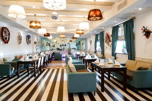 Voyevodino纳巴宫多莫杰多沃酒店的餐厅设有桌椅和吊灯。