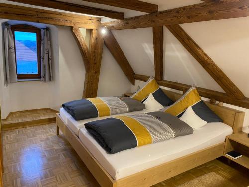 魏勒-锡默贝格Gasthof - Pension - Adler的一间卧室配有黄色和蓝色枕头的床