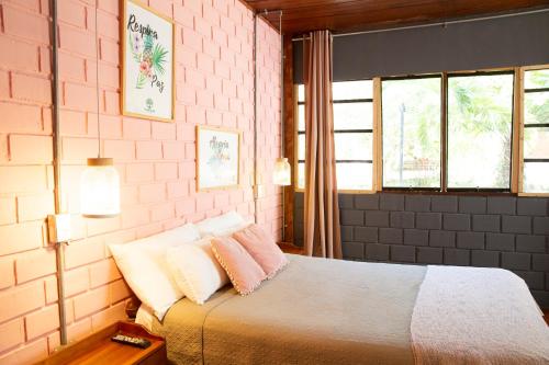 塔拉波托CasaBosque的一间卧室配有一张床和粉红色的砖墙