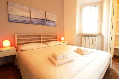 安科纳Uno sguardo sul mare - appartamento的卧室配有带毛巾的大型白色床