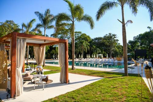 伊瓜苏Sanma Hotel的棕榈树泳池旁的婚礼凉亭