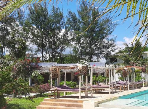 帕杰Jaribu Beach Hotel的一个带游泳池的度假村和一个度假村