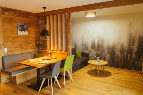 雷滕贝格Ferienwohnung am Dorfbach的一间带桌子和绿色椅子的用餐室