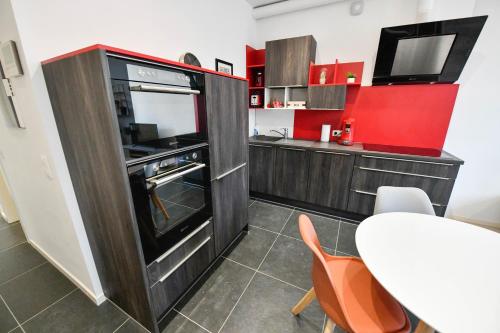 那慕尔Les Cerisiers - Appartement Cosy au Centre de Namur的一间带桌子和电视的小厨房