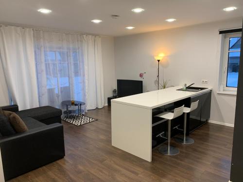 派尔努Pärnu Lubja Apartments的厨房以及带白色柜台和沙发的客厅。