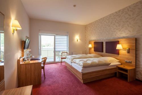 Schwabenheim费芬霍芬酒店的酒店客房设有一张大床和一张书桌。