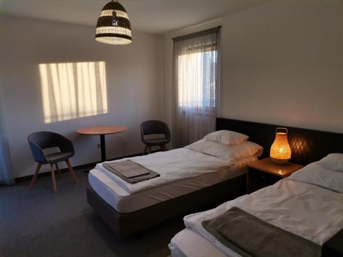 科马罗姆Jonathan Bed&Pizza的一间卧室配有两张床和一张桌子及椅子