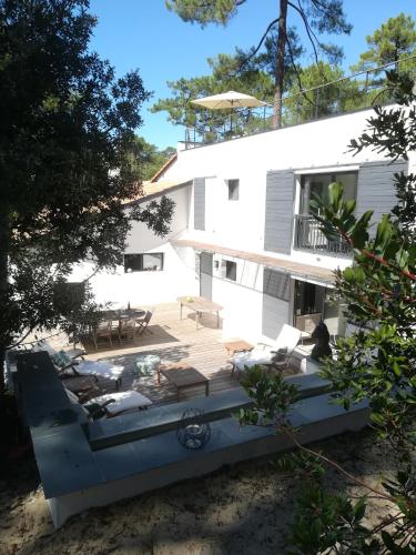 拉特斯特德布赫Villa Paradis Pyla sur Mer的白色的房子,配有甲板和椅子