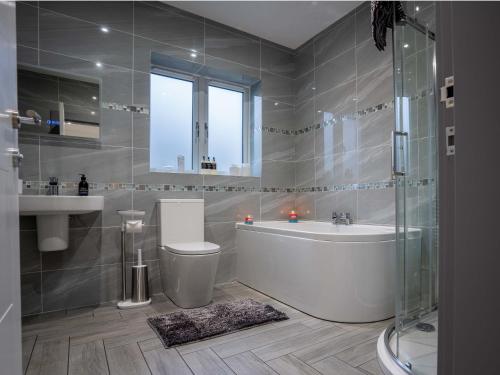 皮特洛赫里Heather House , luxury holiday house in Pitlochry的带浴缸、卫生间和盥洗盆的浴室