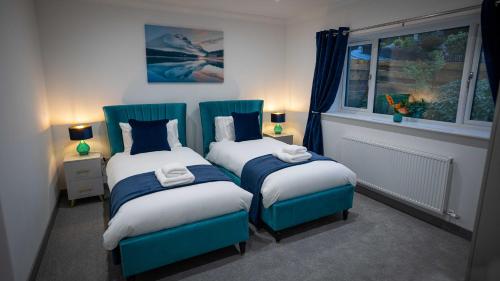 皮特洛赫里Heather House , luxury holiday house in Pitlochry的一间卧室设有两张单人床和一个窗户。
