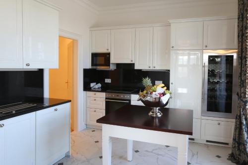 维也纳美泉宫豪华套房公寓的厨房配有白色橱柜和一碗桌上的鲜花