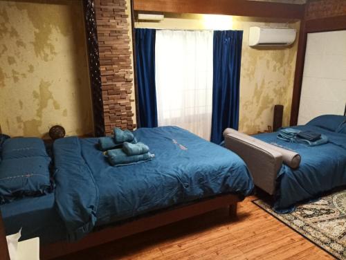 伊豆Ryokan La Luna - Vacation STAY 22160v的一间卧室配有两张带蓝色床单和镜子的床