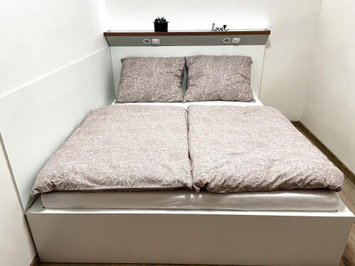 日利纳Apartmán Rajecké Teplice的一张白色的床,上面有两个枕头