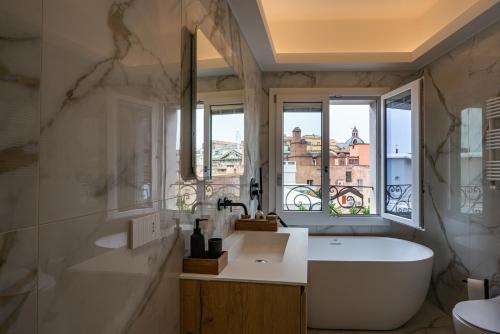 博洛尼亚PANORAMA APARTMENT的带浴缸、水槽和窗户的浴室