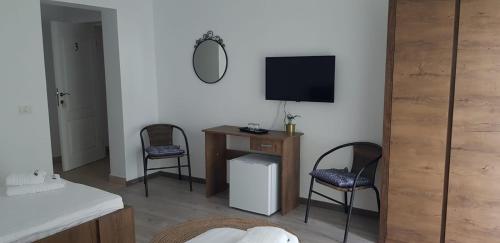 泰基尔吉奥尔PENSIUNEA LA CUCI的客厅配有两把椅子和电视