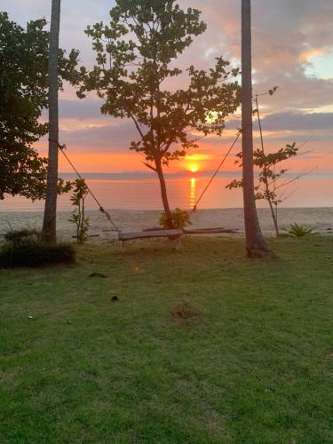 俊穆岛俊穆岛阳光微笑海滩旅馆的秋千在大海前,伴着日落