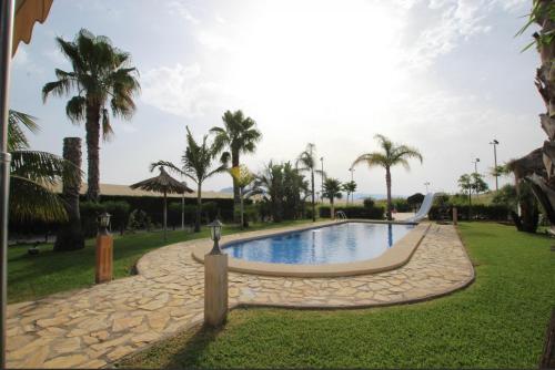 马萨龙港Casa Rural EL CAMPICO的棕榈树公园内的游泳池