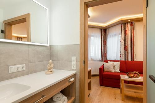 豪尔兹高Dorfstube的一间带水槽和红色沙发的浴室