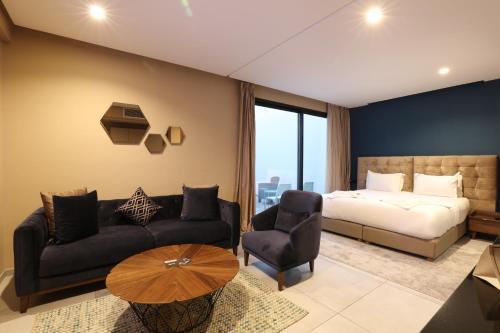 卡萨布兰卡Address Hotel Casablanca的一间卧室配有一张床、一张沙发和一张桌子
