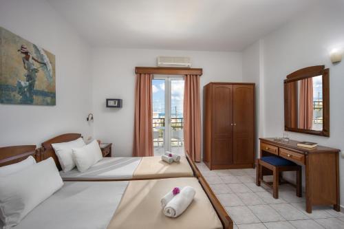 斯塔里斯阿斯特公寓的酒店客房设有两张床、一张书桌和一个窗户。