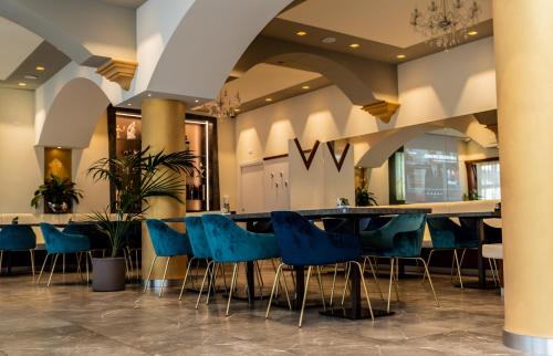 阿拉Hotel Shangri-La的大堂设有长桌子和蓝色椅子