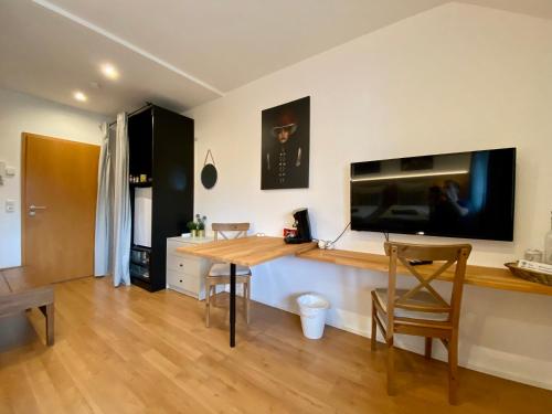 莱茵河畔凯尔Komfortables Doppelzimmer in Kehl Goldscheuer - 1A Guesthouse的客厅配有桌子和平面电视。