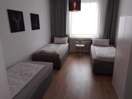 科隆Wohnung in Köln的客房设有两张床、一张沙发和一个窗口。