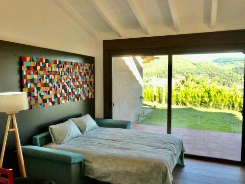 莫斯Casa Nueva de Vigo con Jacuzzi y chimenea的一间卧室设有一张床和一个滑动玻璃门
