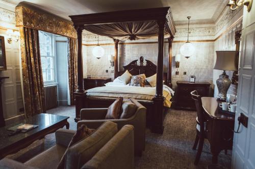 贝图瑟科伊德皇家橡树酒店的一间卧室配有天蓬床和沙发