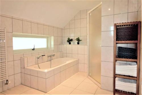 Sint-Oedenrode't Hoefijzer的白色的浴室设有浴缸和水槽。
