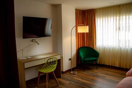 波哥大Hotel Boutique Quinta Camacho的酒店客房配有书桌和绿椅
