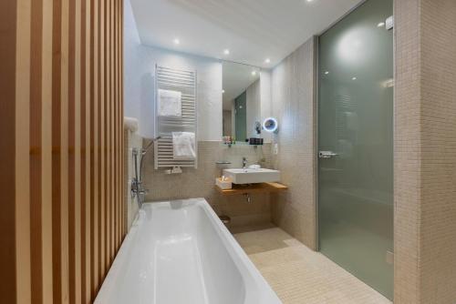 圣安东阿尔贝格MALI by m3的带浴缸、水槽和淋浴的浴室