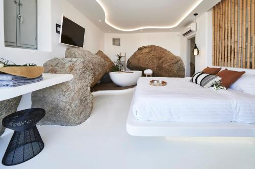 阿诺梅拉Teal Rock Mykonos的一间卧室配有一张床和一些大岩石