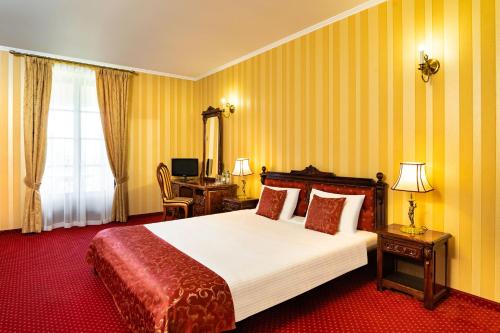 弗沃茨瓦韦克琥珀宫酒店的酒店客房设有一张大床和一张书桌。