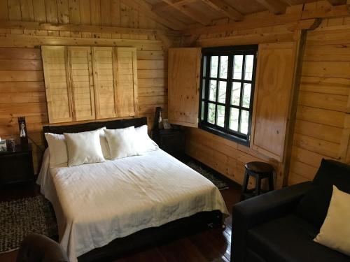 索加莫索Acogedora cabaña de madera en la naturaleza para desconectarse的小木屋内一间卧室,配有一张床