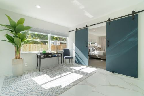 西棕榈滩Elegant 5BR West Palm Beach Home Near Beach的开放式的客房配有书桌和一间卧室。