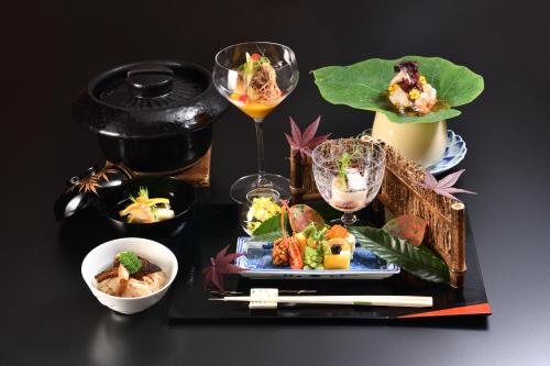 龟冈京汤之花翠泉日式旅馆的一张桌子,上面放着一盘食物和饮料