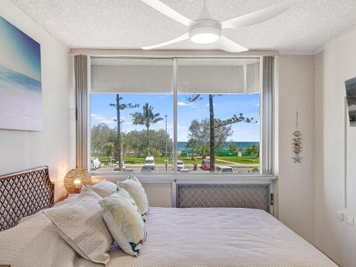 黄金海岸Kooringal Unit 4的一间卧室设有一张床和一个大窗户