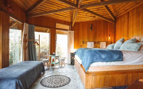 皇后镇Ora Retreat的一间带两张床铺的卧室,位于带木墙的房间内