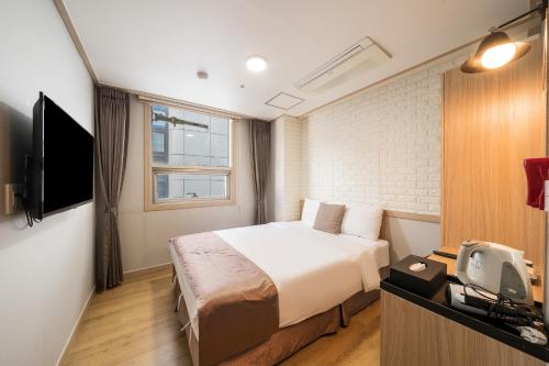首尔明洞休闲酒店的酒店客房,配有床和电视