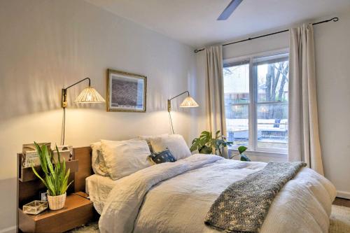 罗利Home with Outdoor Oasis in Downtown Raleigh!的一间卧室配有一张带两盏灯的床和一扇窗户。