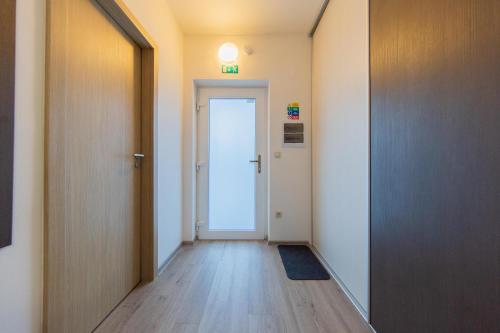 大洛西尼Apartmán Sophia 4 s terasou的一条空的走廊,有门和门垫