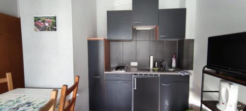 施托尔科Pension und Ferienwohnung Walther的一间小厨房,配有不锈钢用具和桌子