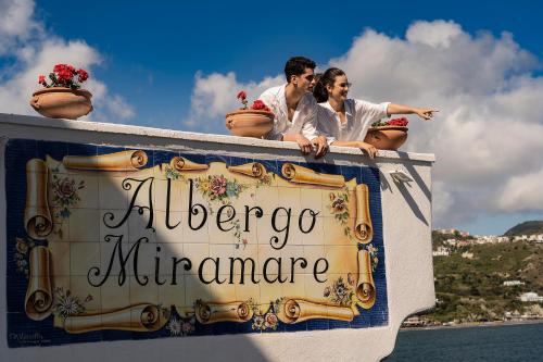 伊斯基亚米拉马雷海Spa度假酒店的坐在船背上的男人和女人