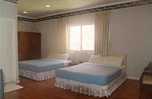 Hsin-hsien-ts'un富仙境的一间卧室设有两张床和窗户。