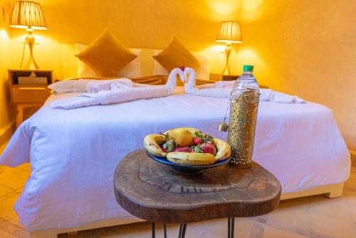 马拉喀什利亚德洛乌亚酒店的一张带一碗水果和一瓶水的床