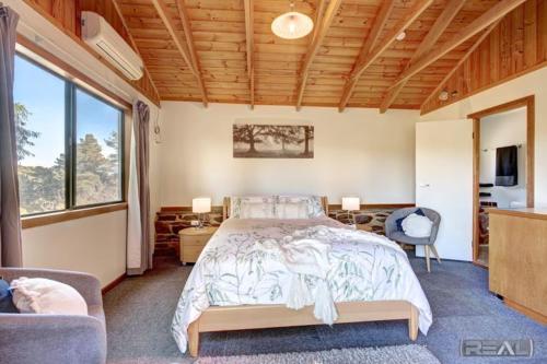 Red CreekHighRoost Bed & Breakfast accomodation - rural escape的一间卧室设有一张床和一个大窗户